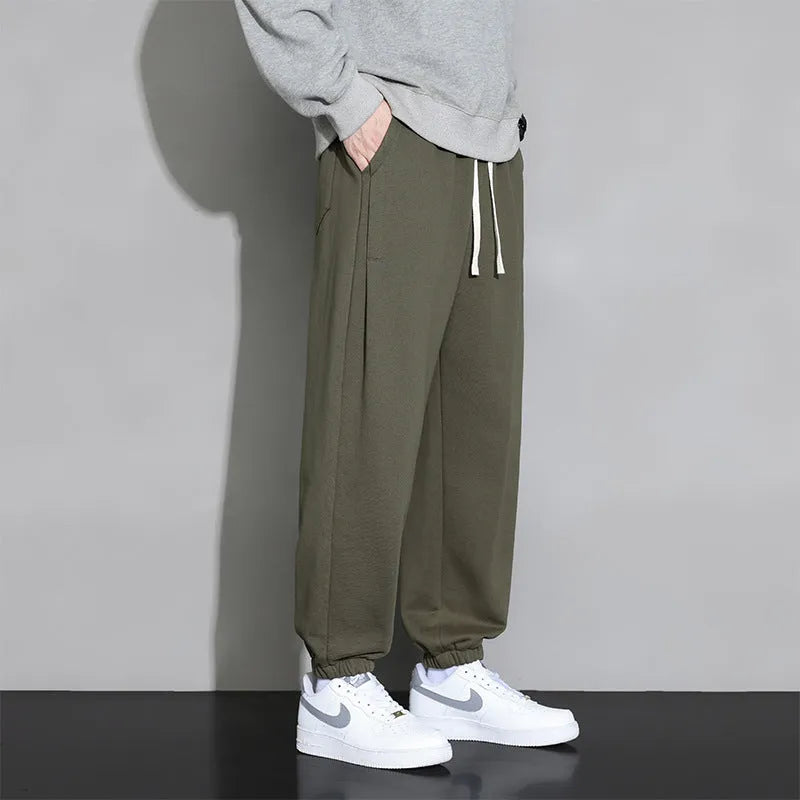Men's loose grey cotton sports trousers with elastic waistband on hanger