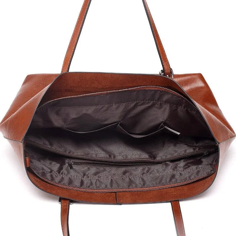 Brown waxed cowhide cross-body handbag with zip, showing two compartments and adjustable strap.