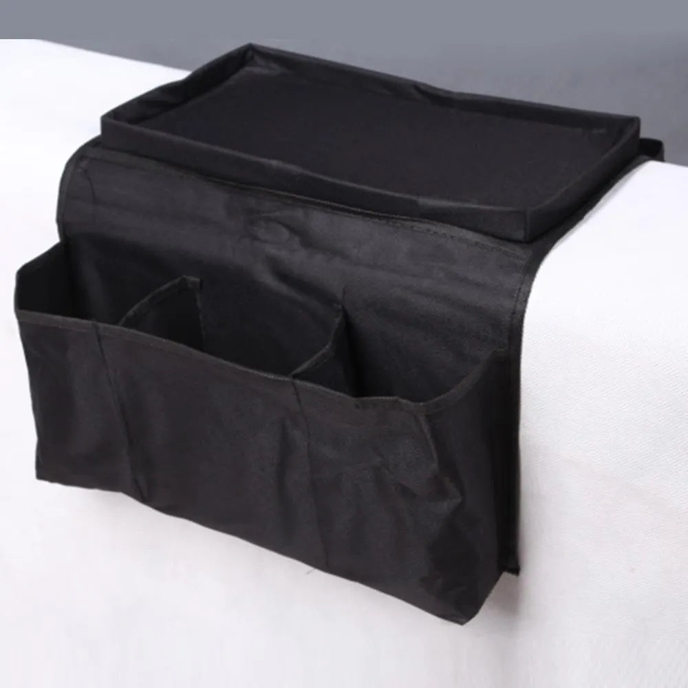 Black Oxford fabric sofa armrest organiser bag with 6 pockets on a couch handrail