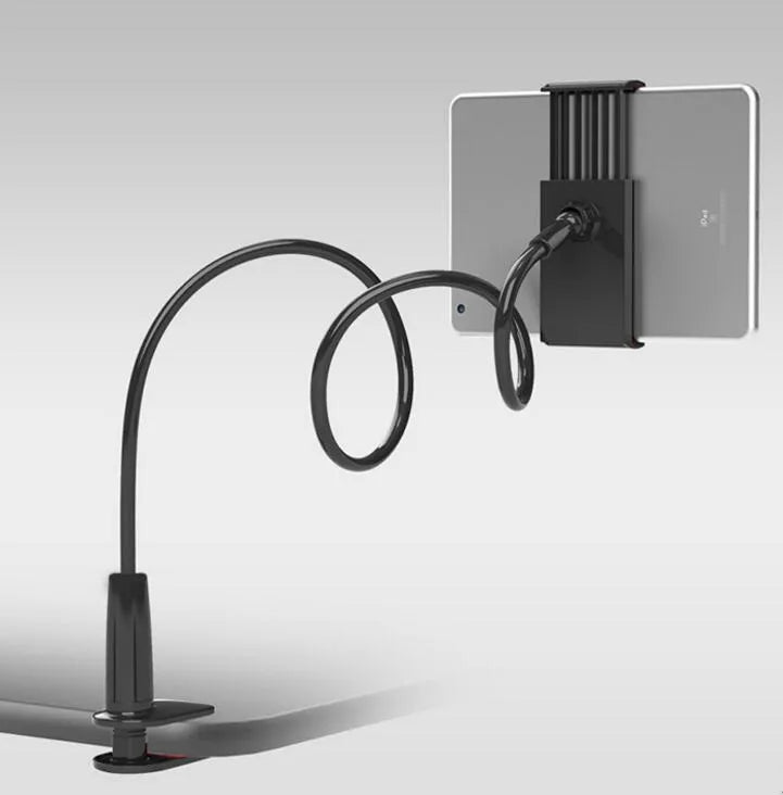 Black bedside phone holder with long arm extended, holding a mobile phone at an angle on a wooden table.