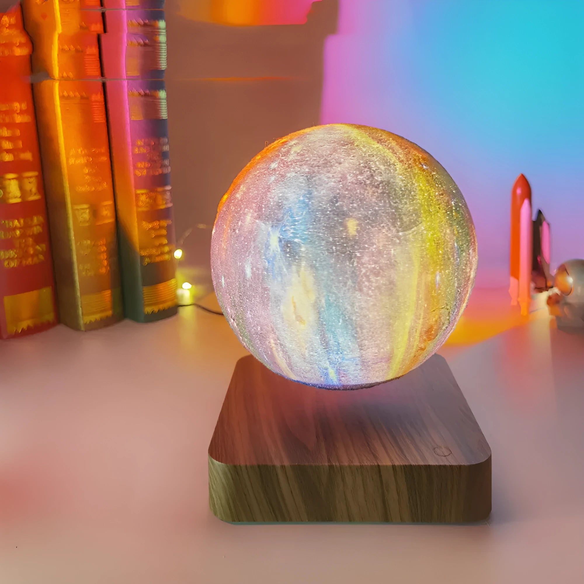 Walnut-coloured magnetic levitation base with floating galaxy-patterned moon lamp illuminated in dark setting