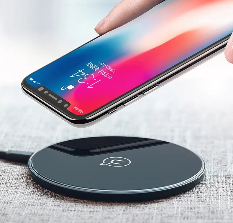 Black glass disc wireless charger with LED indicator light on smooth surface