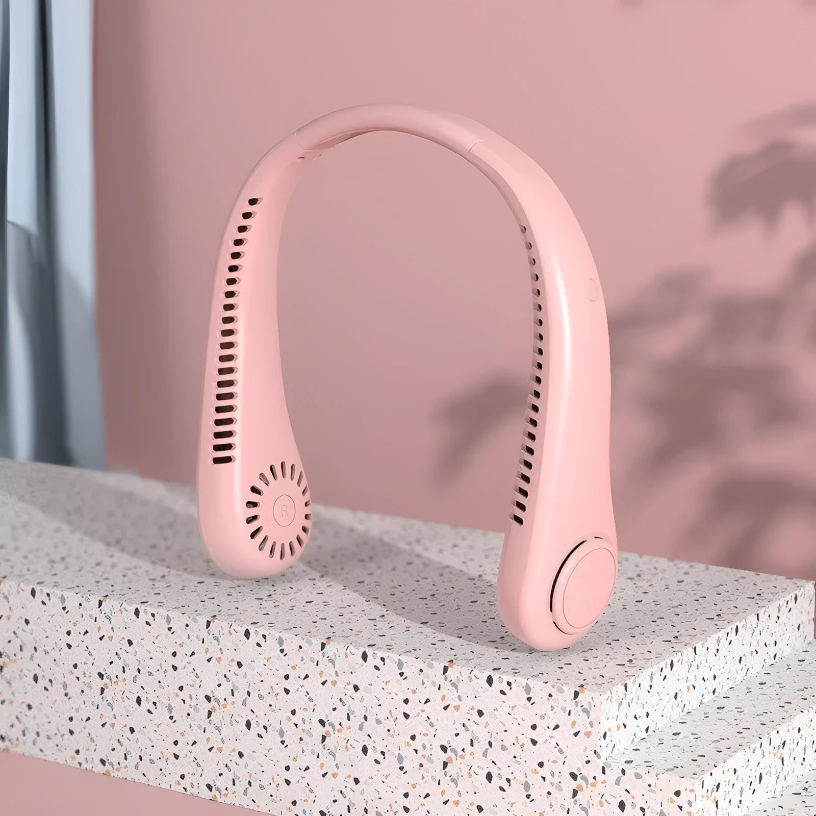 Pink portable USB rechargeable bladeless neck fan with an adjustable neckband.