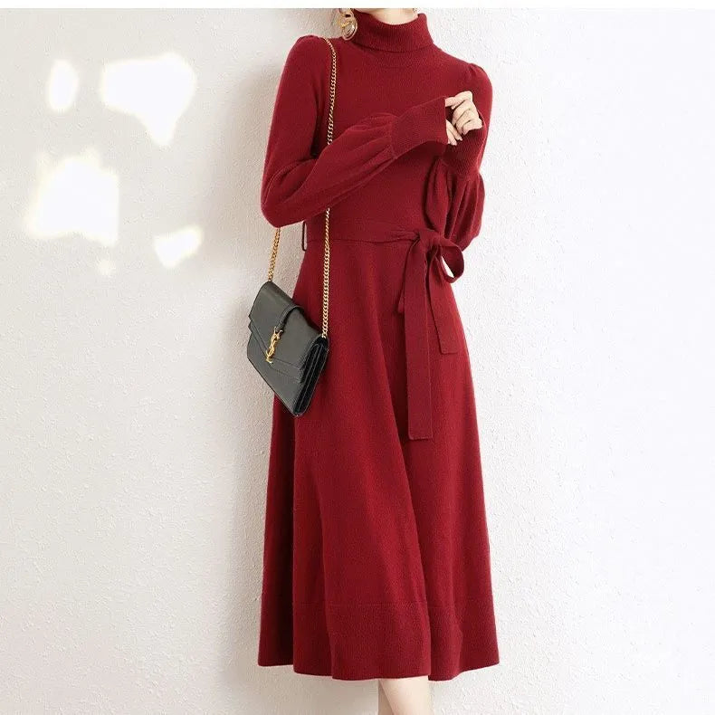 A rose red turtleneck knit dress with long sleeves, a loose hem, and an elastic waist on a hanger.