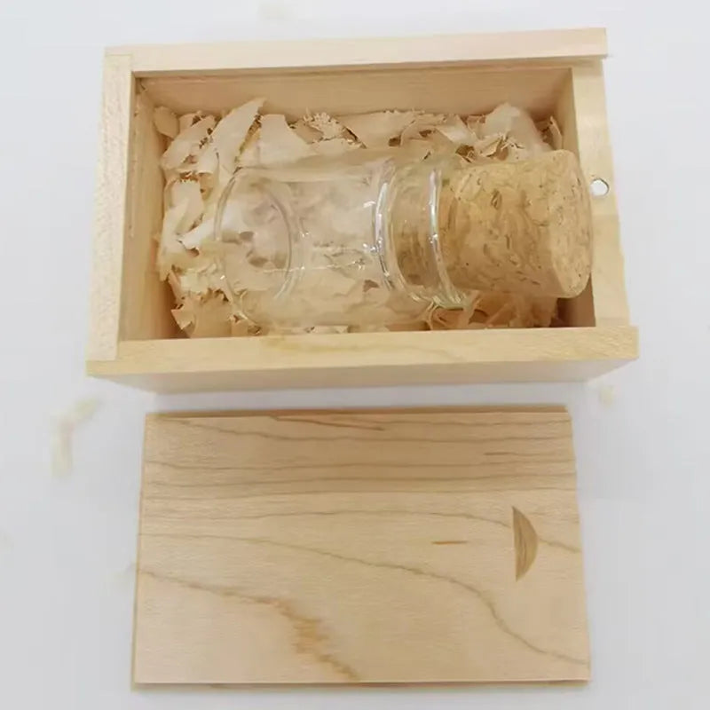 Wooden and transparent glass bottle-shaped USB flash drive on a wooden surface.