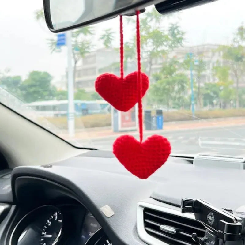 Green and white knitted wool car plant ornament hanging from a rope