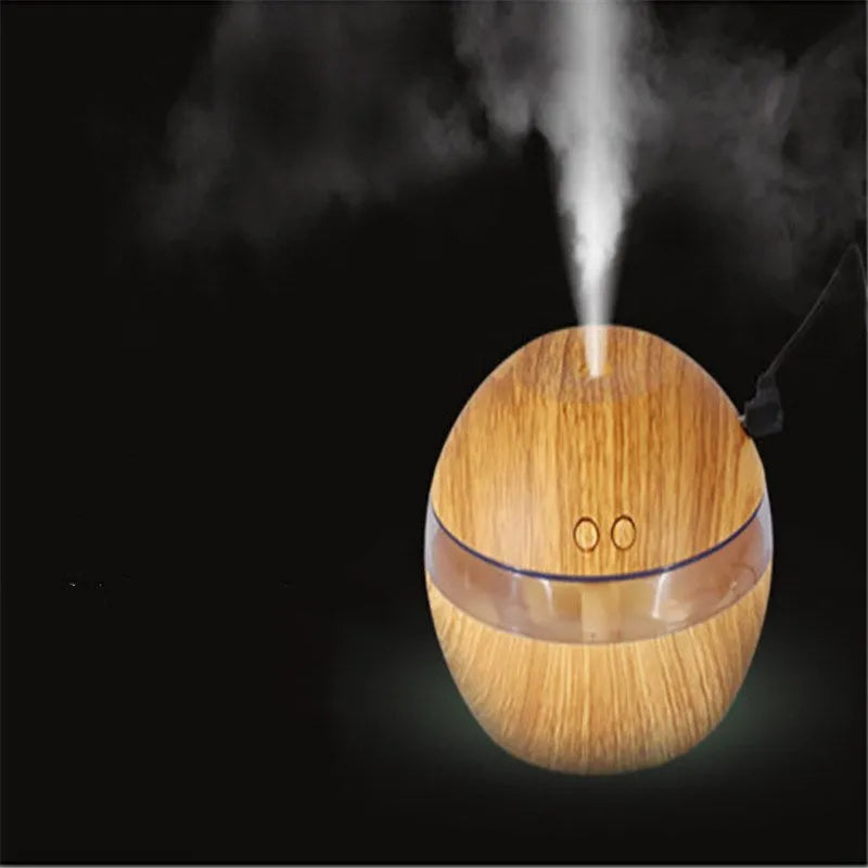 Brown wood grain portable USB humidifier on a desk next to a laptop.
