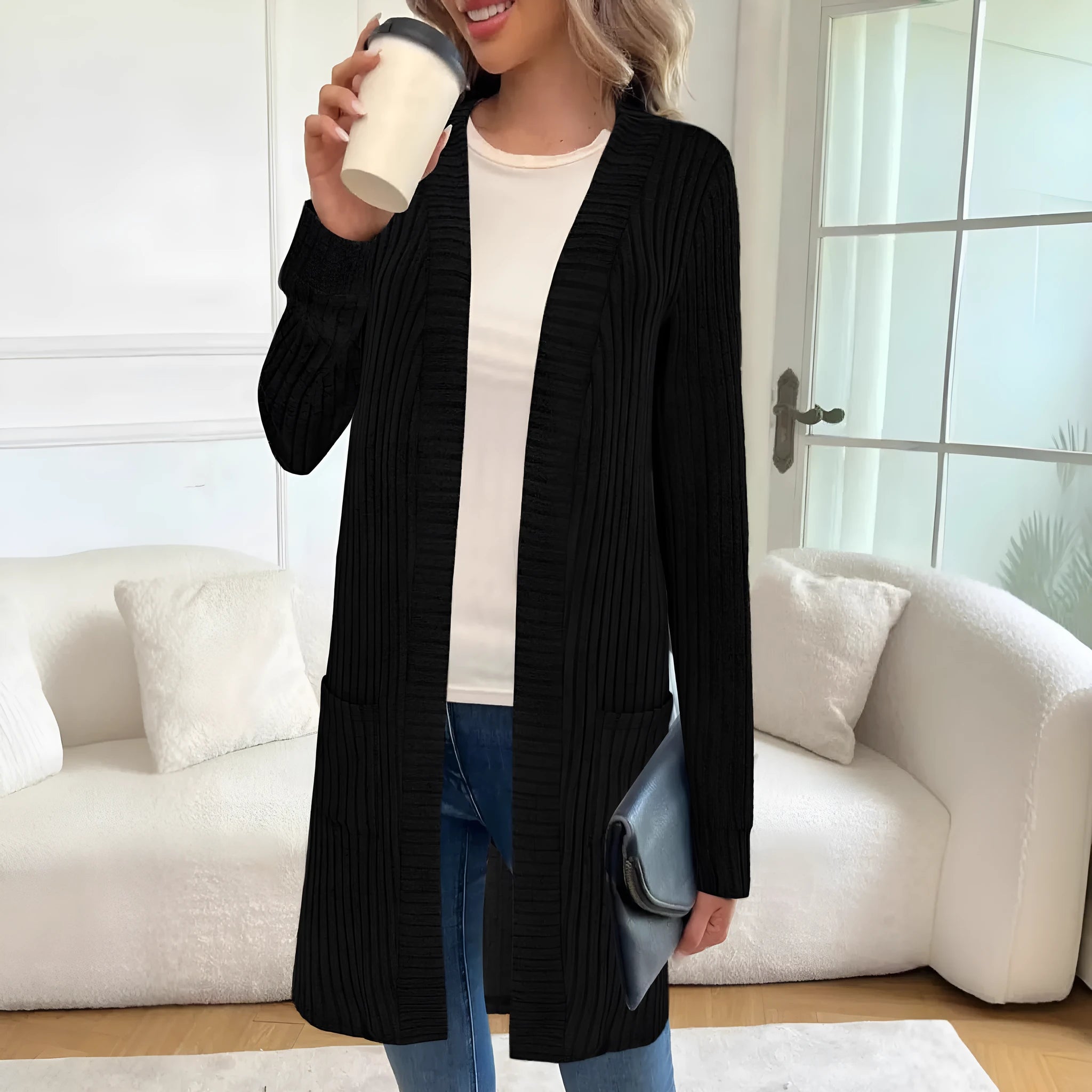 Long sleeve loose fit knitted cardigan jacket in black, shown on a hanger.
