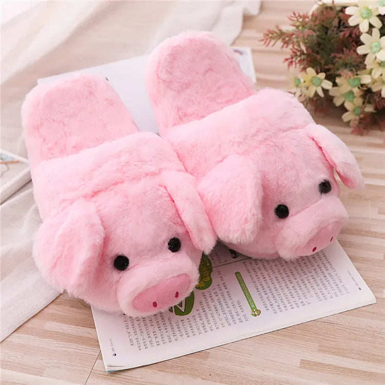 Pink pig-themed plush house slippers for adults on a plain background.
