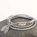 Leather charm friendship bracelet with buckle closure in black brown on white background