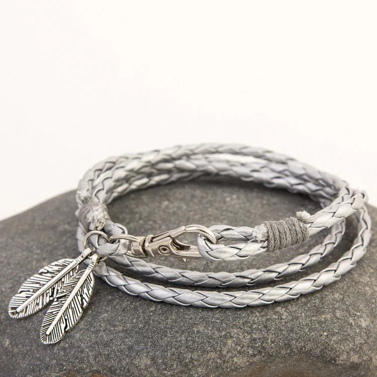 Leather charm friendship bracelet with buckle closure in black brown on white background