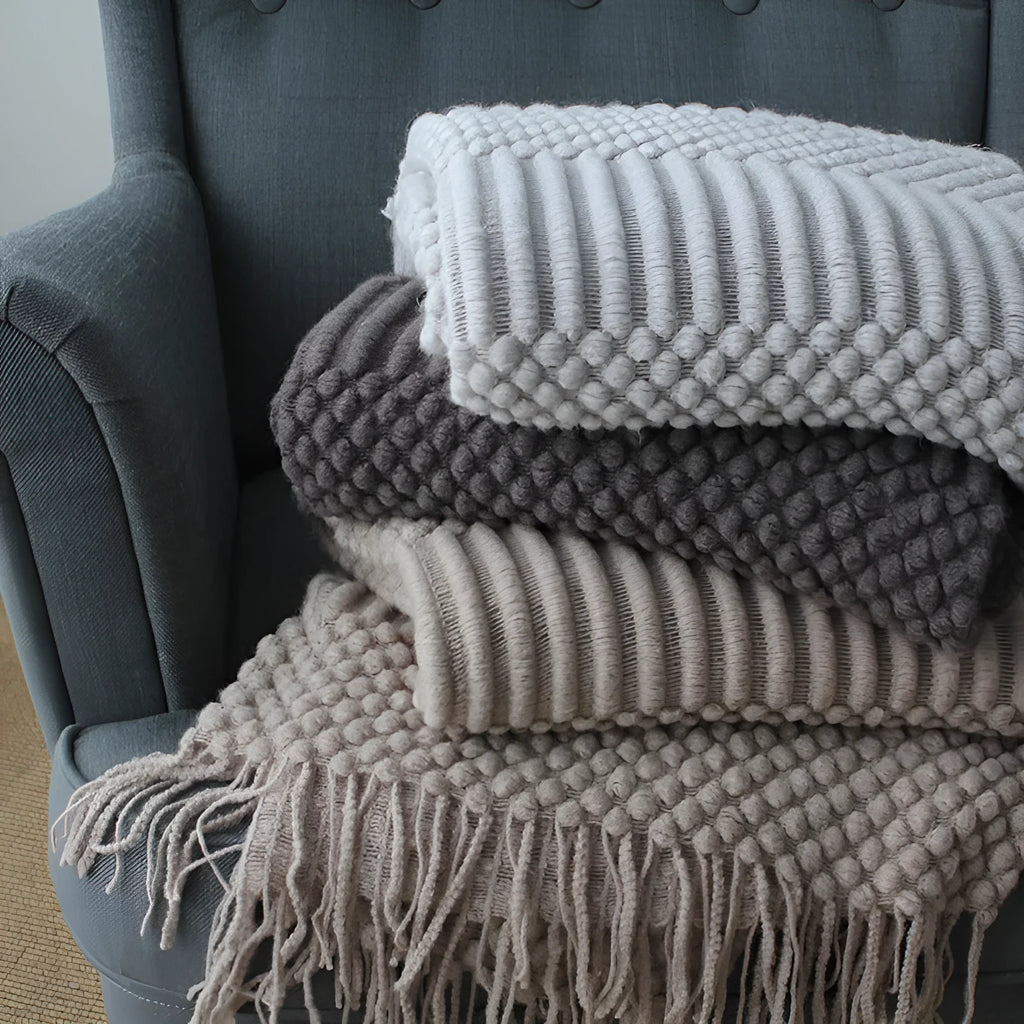 Small light grey polyester nap blanket folded, showing its texture and size.