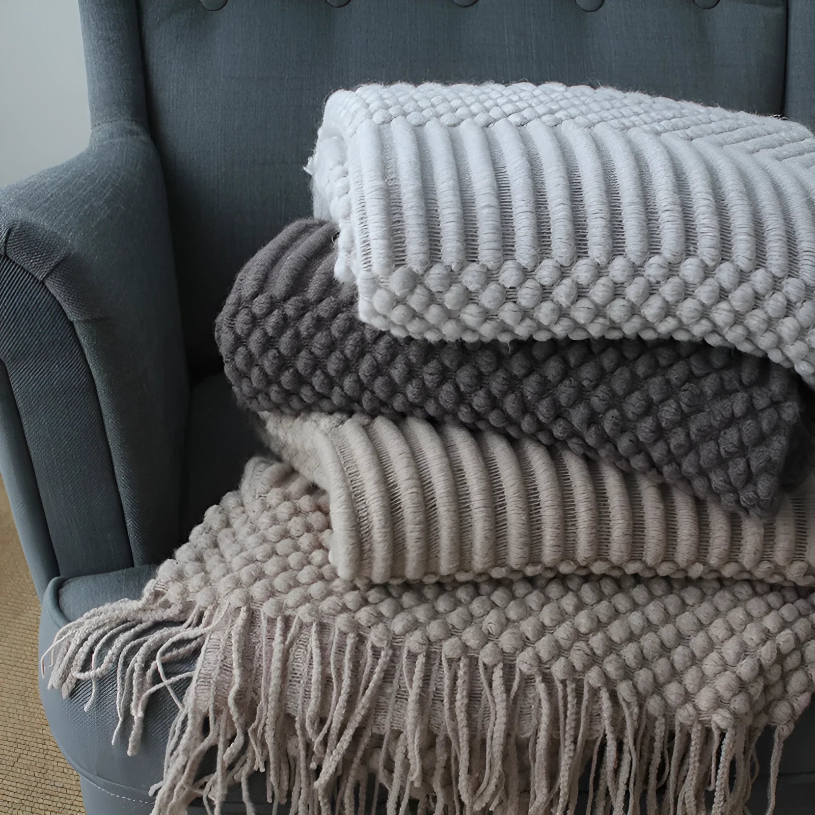 Small light grey polyester nap blanket folded, showing its texture and size.