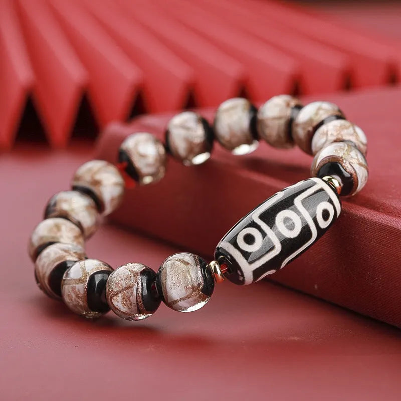 Close-up of a handmade Chinese-style bracelet with coloured glaze lucky beads on a snake theme.