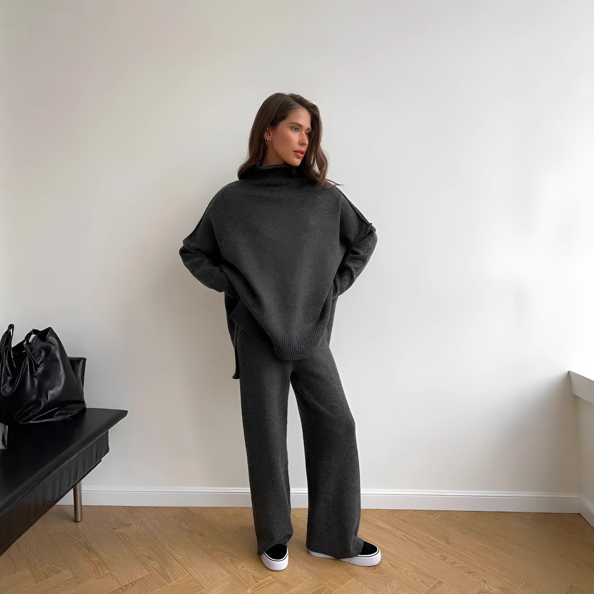 Women's dark grey acrylic knit suit with side-slit hem sweater and matching trousers laid flat.