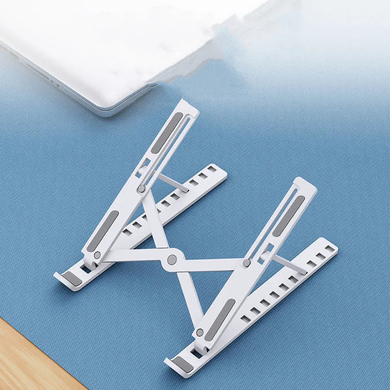 Black foldable laptop stand in an angled position on a wooden desk.