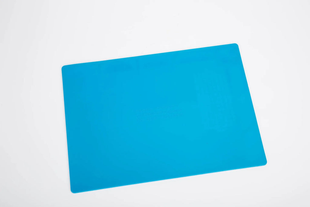 Blue silicone anti-skid work desk mat for watch repair and tool organisation.