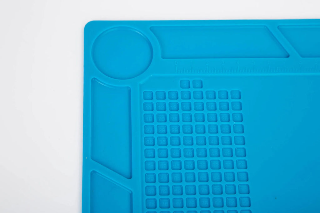 Blue silicone anti-skid work desk mat for watch repair and tool organisation.