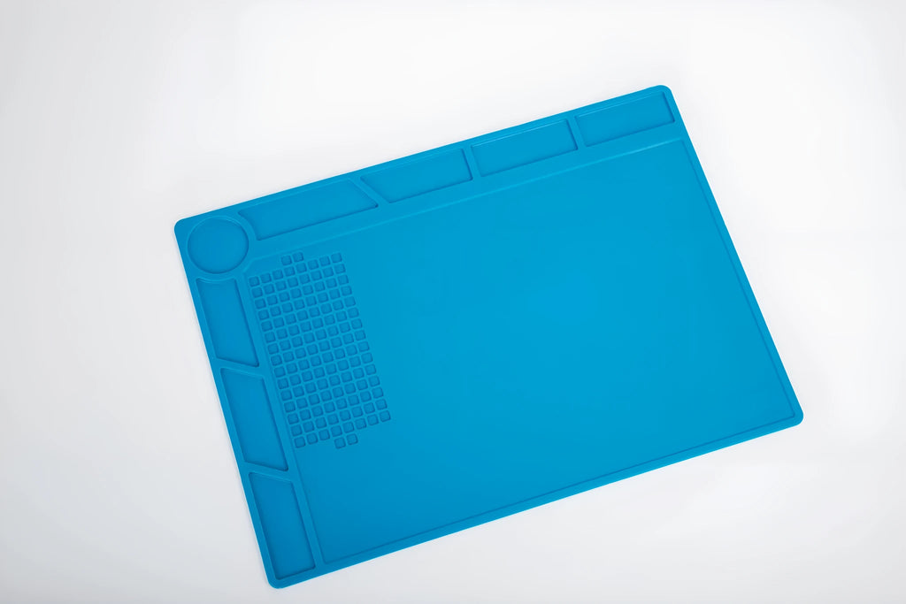 Blue silicone anti-skid work desk mat for watch repair and tool organisation.