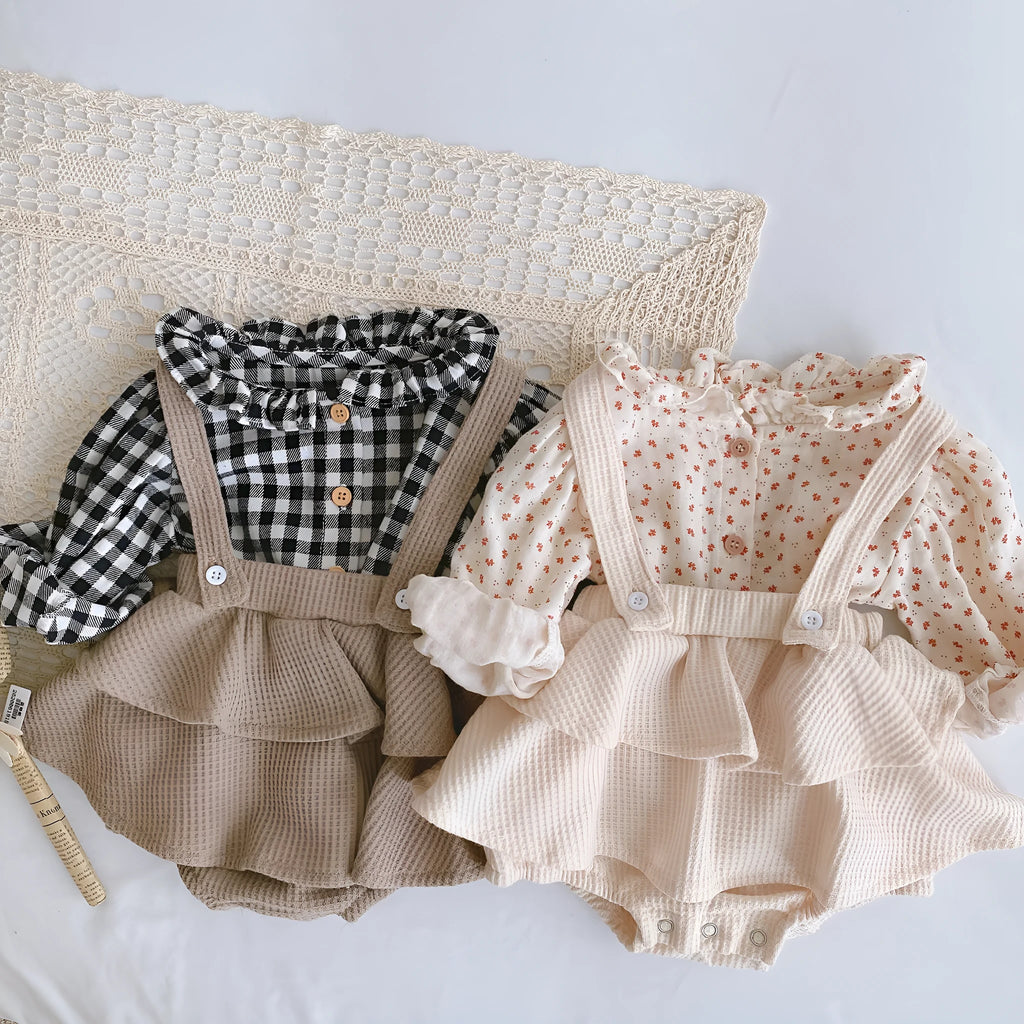 Baby girl wearing a cotton pleated skirt romper with lotus leaf sling design in apricot colour