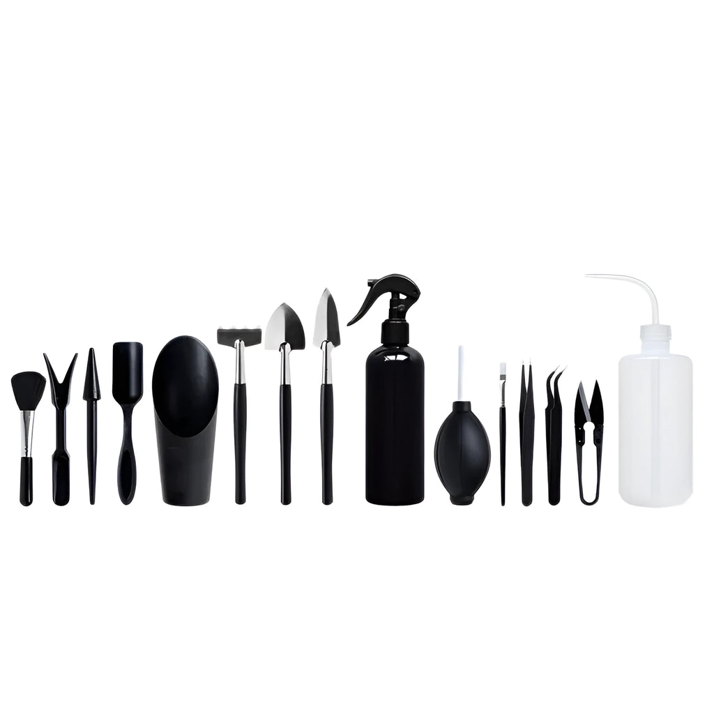 Black plastic and metal mini garden tool set for succulents, including small shovel, tweezers, brushes, bottle, and a square cushion.