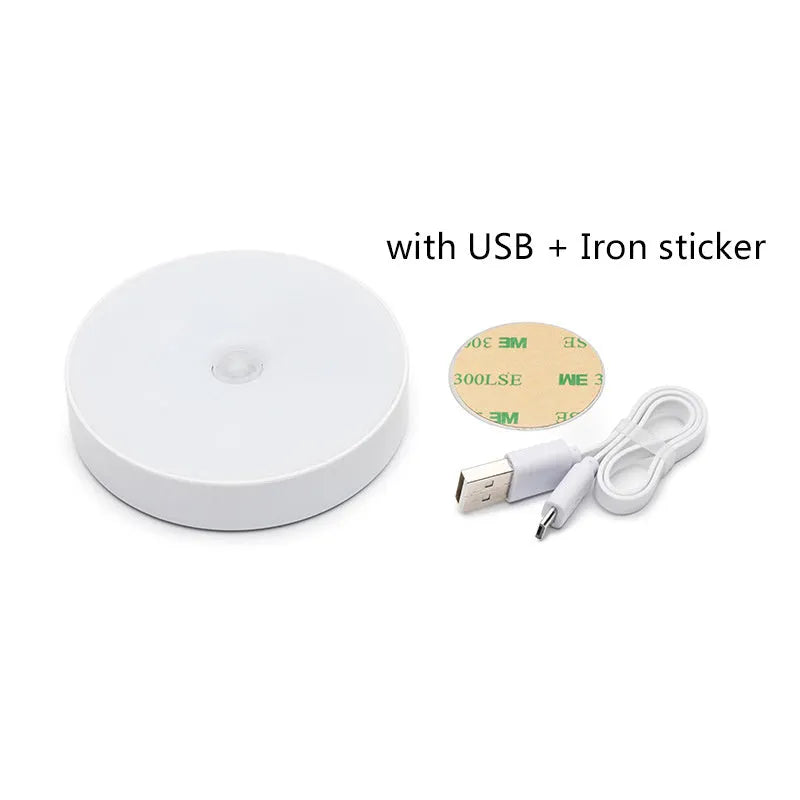 Small circular white USB-rechargeable motion sensing LED night light with adhesive backing.