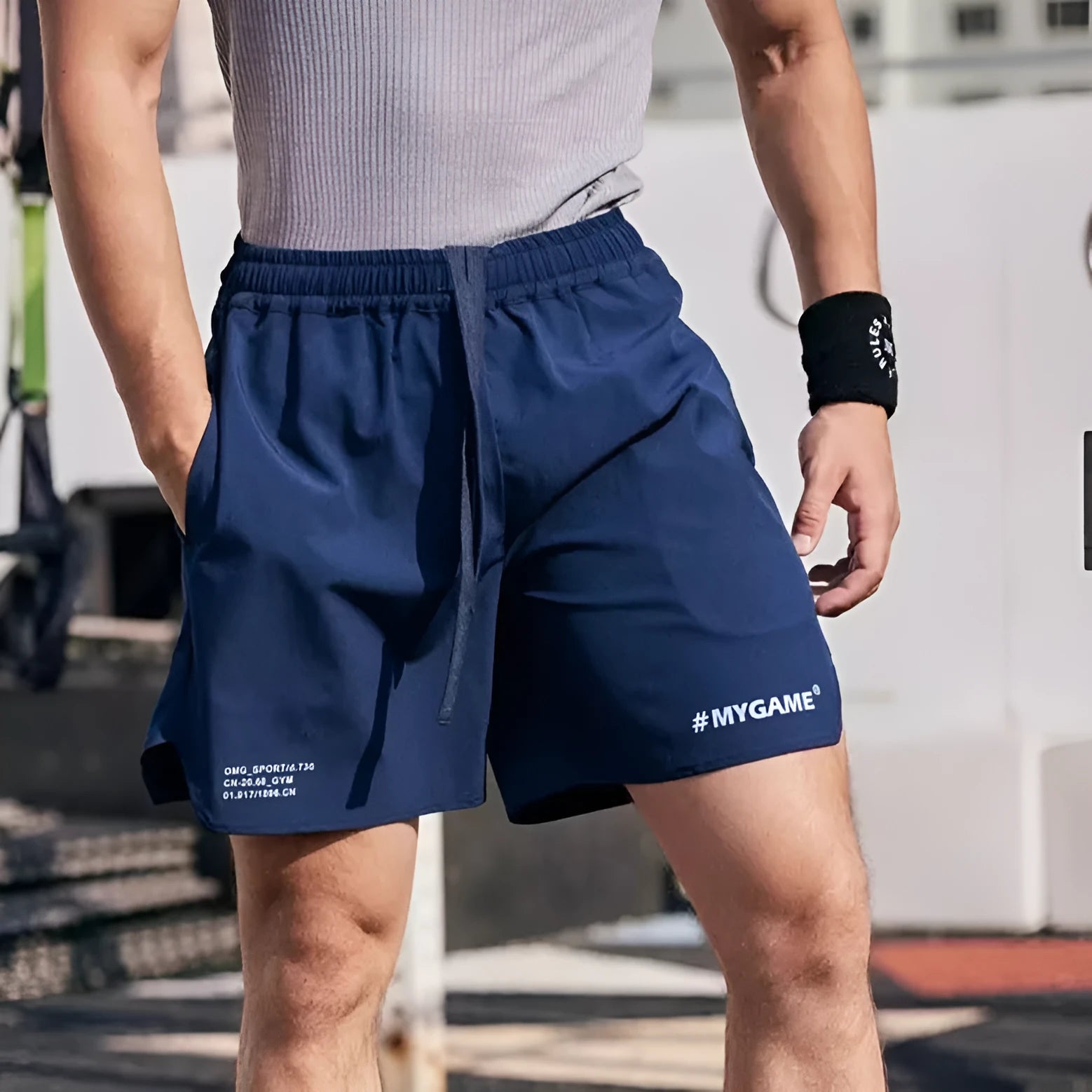 Men's grey fitness shorts with a four-point training design, shown on a model, highlighting the short length and elastic fabric.