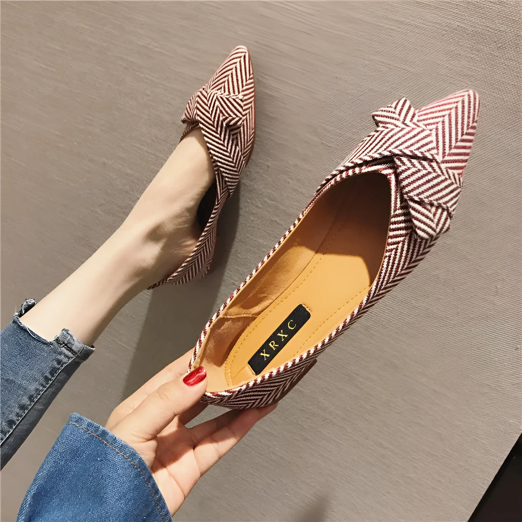 Women's pointed toe shallow mouth shoes in red with a low flat heel on a white background.