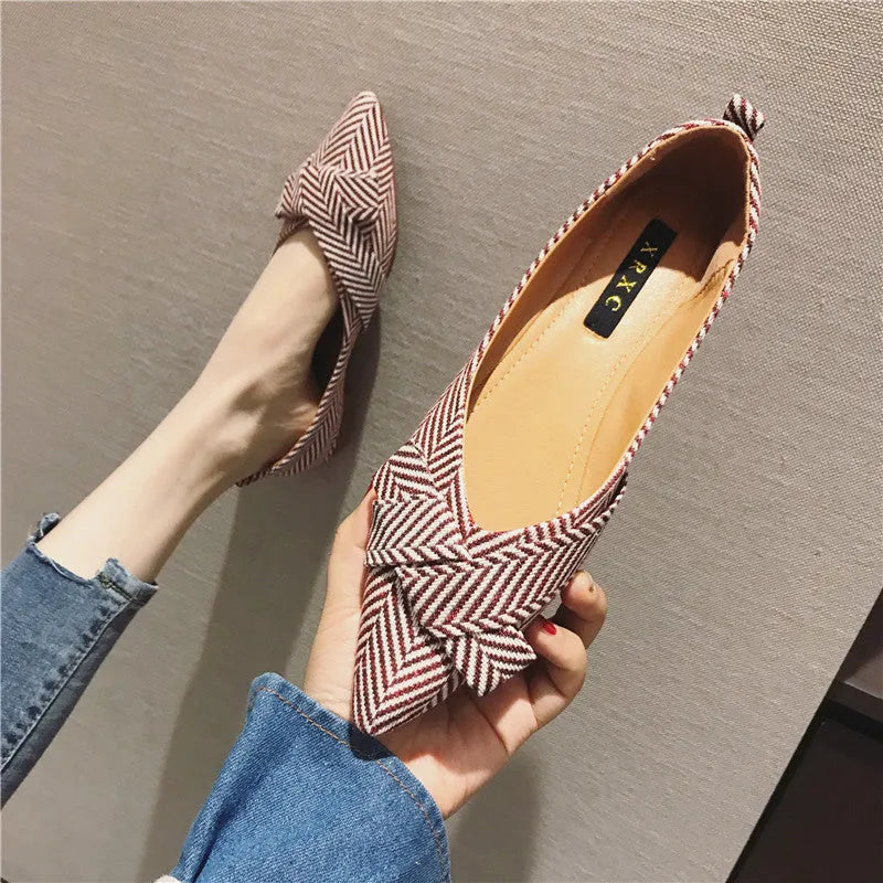 Women's pointed toe shallow mouth shoes in red with a low flat heel on a white background.