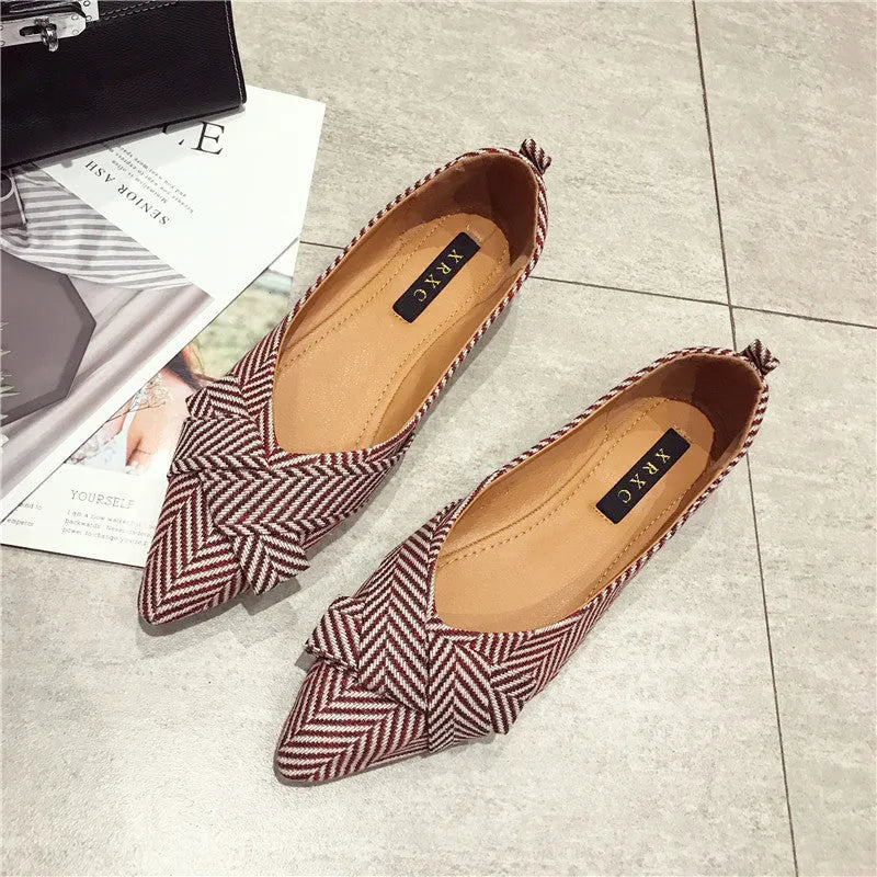 Women's pointed toe shallow mouth shoes in red with a low flat heel on a white background.