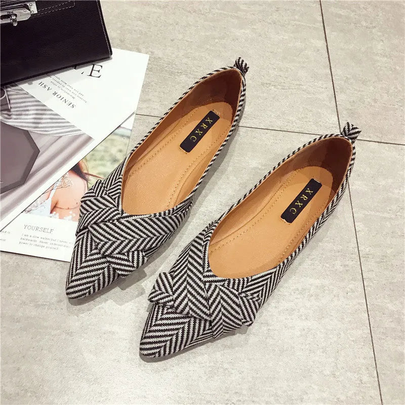 Women's pointed toe shallow mouth shoes in red with a low flat heel on a white background.