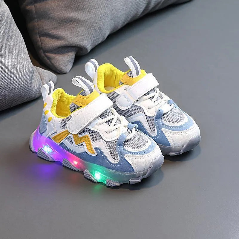 Black children's mesh sneakers with velcro strap and rubber sole on a plain background.