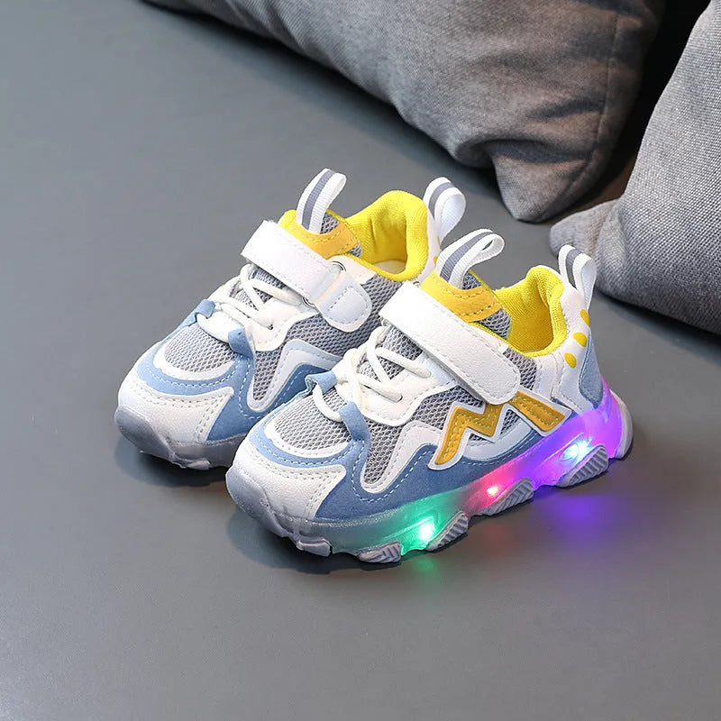 Black children's mesh sneakers with velcro strap and rubber sole on a plain background.