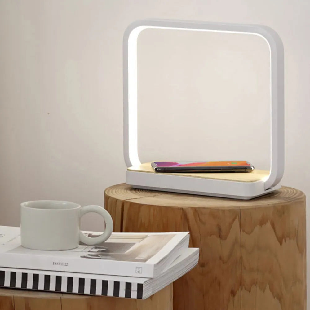 Modern white smart bedside lamp with voice control and USB cable on a wooden nightstand.