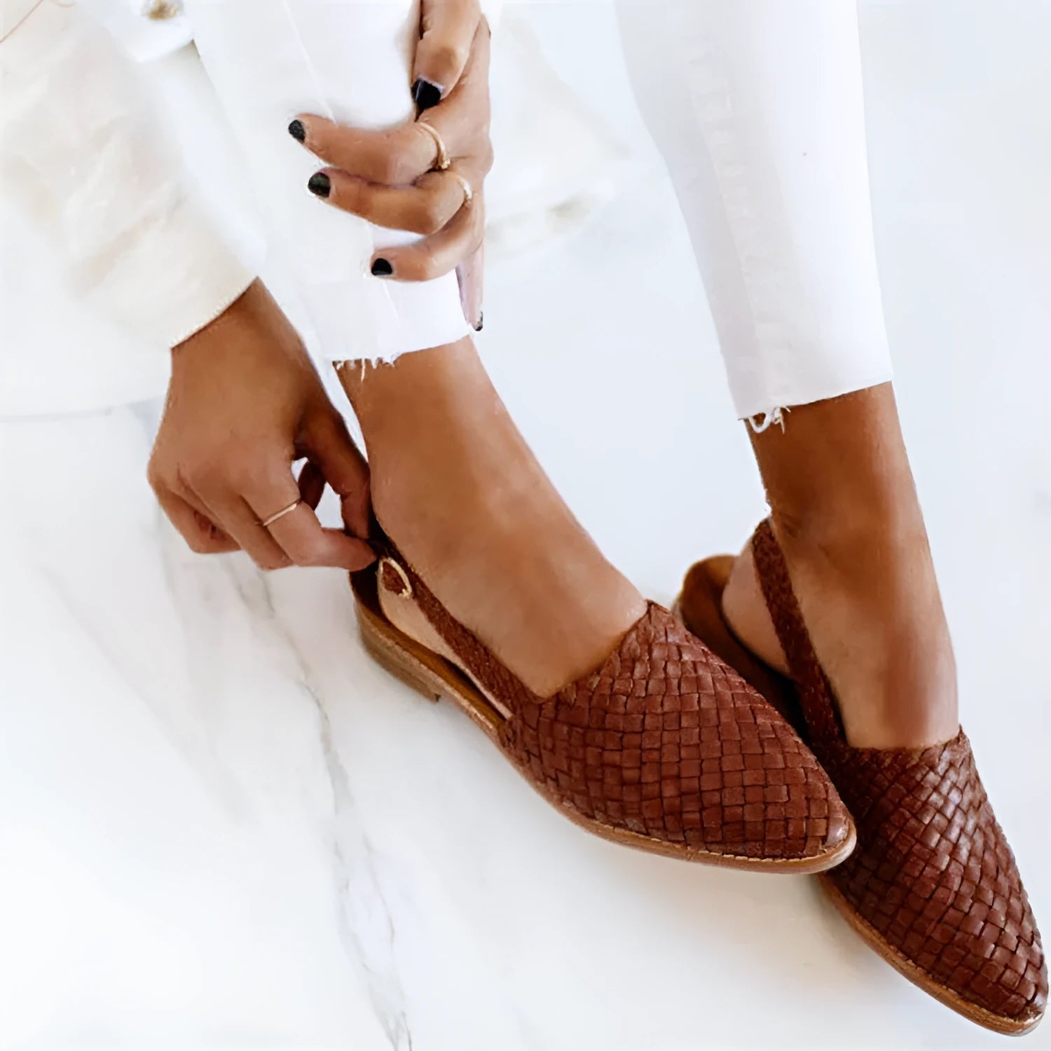 A pair of pointed-toe baotou flat sandals with an adjustable buckle strap, shown in a dark brown colour.