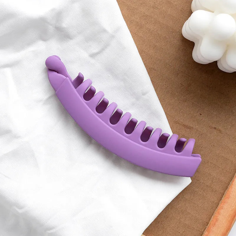 Banana hair clip claw with matte finish in black showing U-shaped design and oversized teeth