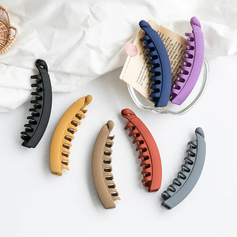 Banana hair clip claw with matte finish in black showing U-shaped design and oversized teeth