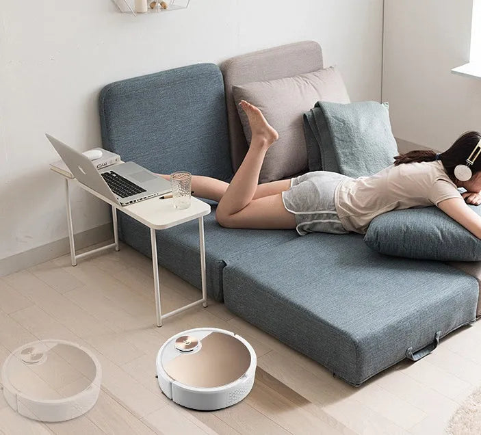 Golden robotic vacuum cleaner with remote control on a home floor
