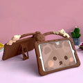 Brown cartoon-style silicone sleeve with a folding stand for an iPad tablet on a wooden table.