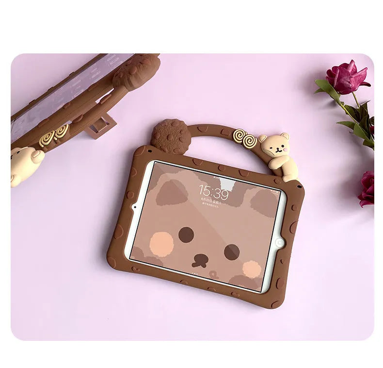 Brown cartoon-style silicone sleeve with a folding stand for an iPad tablet on a wooden table.