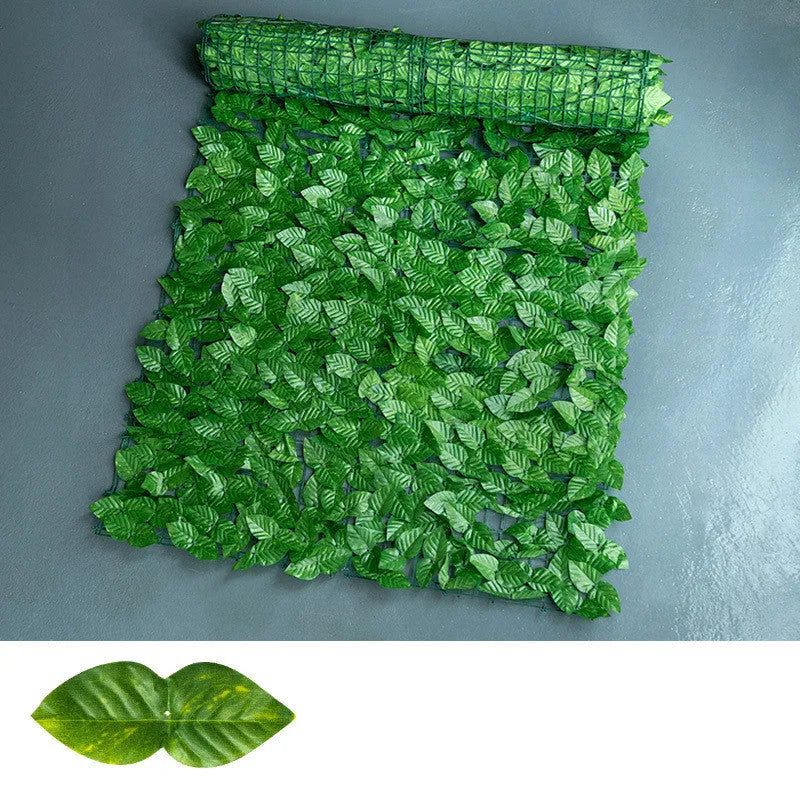 Plastic artificial fence panel with green colour-printed leaf design in a garden setting