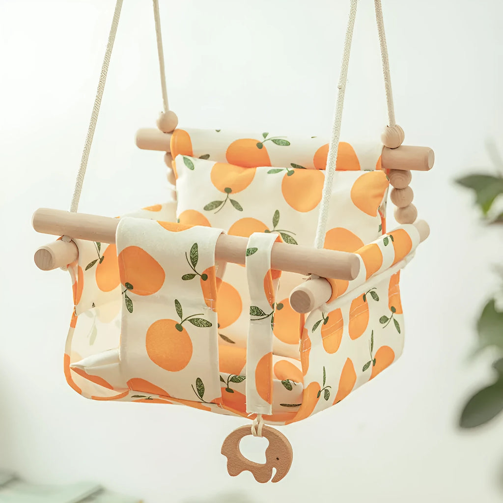 Cotton canvas baby swing chair with wooden frame and cushion, hanging with decorative tassels.