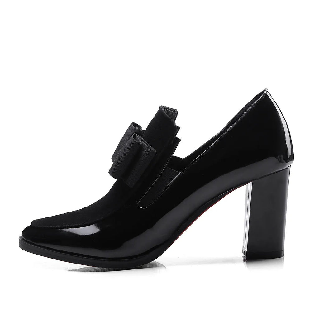 Black patent leather women's high heel shoes with a thick heel and square toe on a rubber sole