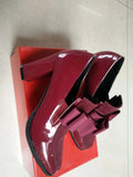 Black patent leather women's high heel shoes with a thick heel and square toe on a rubber sole