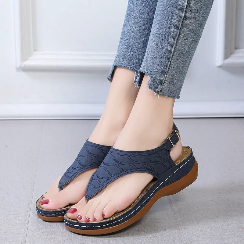 Women's wedge heel flip flop sandals with an adjustable back strap in solid black.