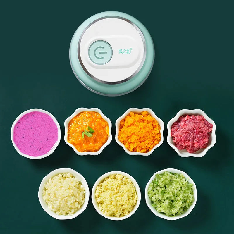 Portable white electric food chopper with transparent cup and stainless steel blades on a kitchen counter.