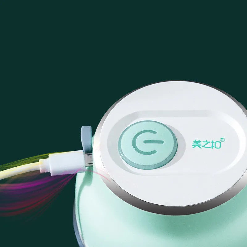 Portable white electric food chopper with transparent cup and stainless steel blades on a kitchen counter.