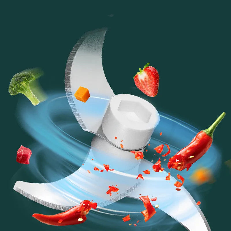 Portable white electric food chopper with transparent cup and stainless steel blades on a kitchen counter.