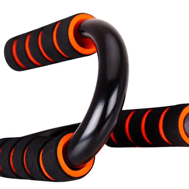 Black parallettes push up stands made of steel pipe with foam grips, 19x13x13cm, on a flat surface