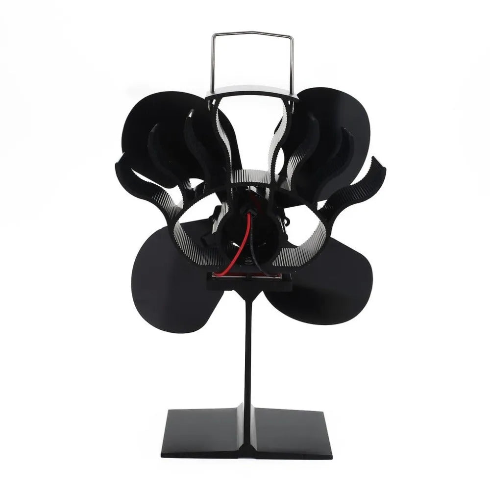 Black Yotsuba style thermodynamic fireplace fan on a fireplace, showing metal blades and compact 17x11.5x25cm size.